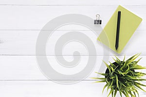 White office desk wooden table background with mock up notebooks and pencil and plant.