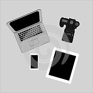 White office photography desk table with laptop, tablet, camera.