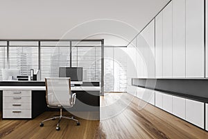 White office room with table and computer, window with city view