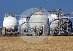 White oil tanks and agriculture field