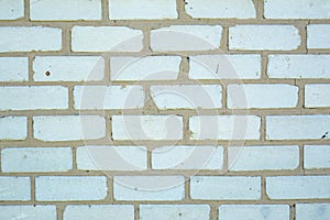 White old faded bricks background with flaws and splits