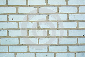 White old faded bricks background with flaws and splits photo
