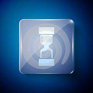 White Old hourglass with flowing sand icon isolated on blue background. Sand clock sign. Business and time management