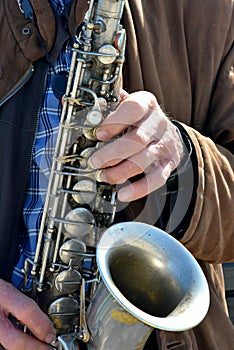 White old male hands playing saxophone