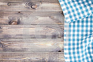 White old wooden table with blue checkered tablecloth, top view with copy space