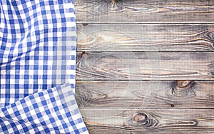 White old wooden table with blue checkered tablecloth, top view with copy space