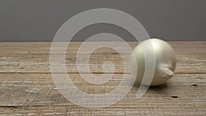 White onion rolls on a wooden surface on a gray background.