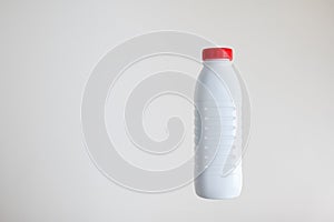 White opaque plastic bottle with a red cap isolated on white background, no label