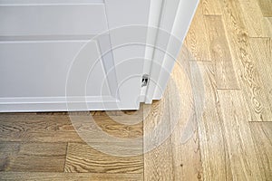 White open door in room with elegant oak parquet flooring