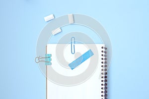 White open notebook with blue elements and gum on a light blue background