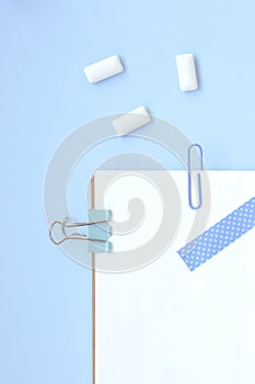 White open notebook with blue elements and gum on a light blue background