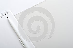White open notebook with pen on gray and white background. Concept office desk, business. Top view, flat lay, copy space