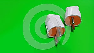 White and orance electric plug on green isolated photo