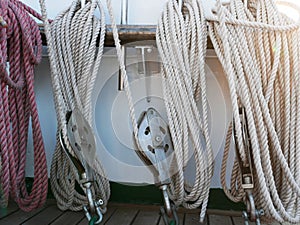 White, orange and black ropes dry on the rail on a sailing ship on a Sunny summer day. The rigging of a sailboat.