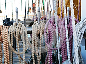 White, orange and black ropes dry on the rail on a sailing ship on a Sunny summer day. The rigging of a sailboat.