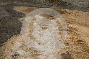 White and orange geothermal area over gray travertine rock, Yell