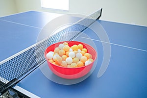 White and orange ping pong ball on ping pong table