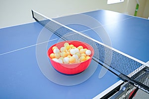 White and orange ping pong ball on ping pong table