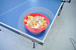 White and orange ping pong ball on ping pong table