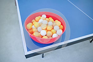 White and orange ping pong ball on ping pong table