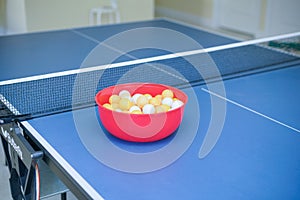 White and orange ping pong ball on ping pong table