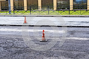 white-orange traffic cones on the city highway during road repairs