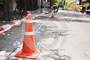 White orange traffic hazard cone on asphalt road repair photo