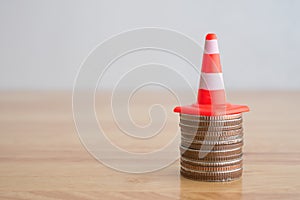 White orange under construction cone on stacked coins with copy space. Revise or reset investment, money saving management plan.