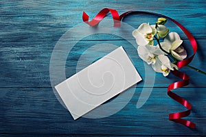 White Orchid and envelope on a blue wooden