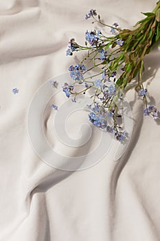 White organic cotton blanket with forget-me-not flowers.