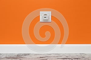 White outlet on orange wall