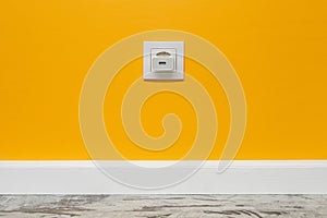 White outlet on yellow wall