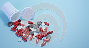 white package a handful of tablets, capsules colored on a blue background. space for text