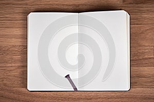 White pages of open notebook on a brown wooden table