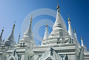 White pagodas of Sanda Muni Paya Buddhist stupa in Mandalay, Myanmar