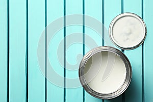 White paint can on blue wooden background, top view.