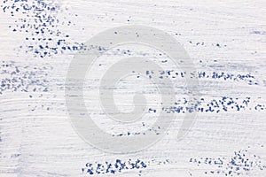 White paint layer on blue textured paper surface