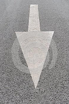 White painted arrow on grey asphalt road