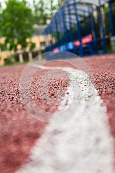 White painted line on rubber running lane, low angle view, close up