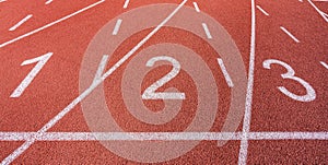 White painted lines and numbers on a running track in a athleticism and sports field.