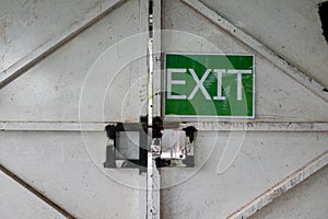 A white painted metal gate with EXIT sign in a building construction site