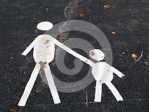 White painted parent and child sign in a parking space with leaves
