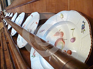White painted plates in a decorative wooden stand