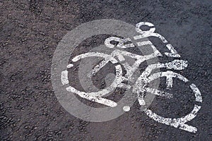 White painted sign for bicycles on an asphalt road
