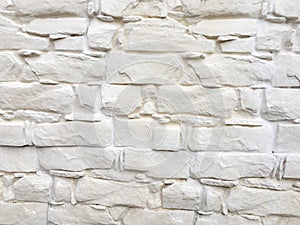 White painted stone wall texture as background. Cracked concrete vintage block stone wall background, old painted wall. Background