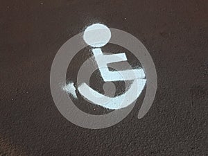 White painted wheelchair or disabled sign on asphalt