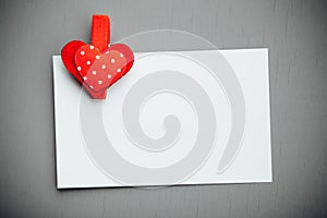 White paper background with red valentine heart clip