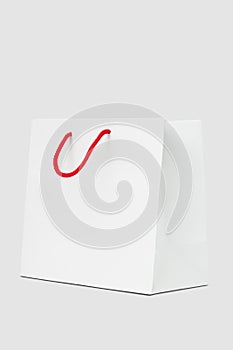 White paper bag with red string handle
