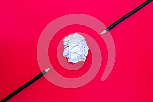 White paper ball with a black pencil on red background.