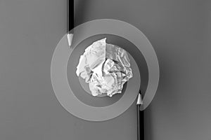 White paper ball with a black pencil on a white background.